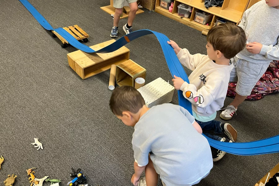 two boys constructing a racetrack together